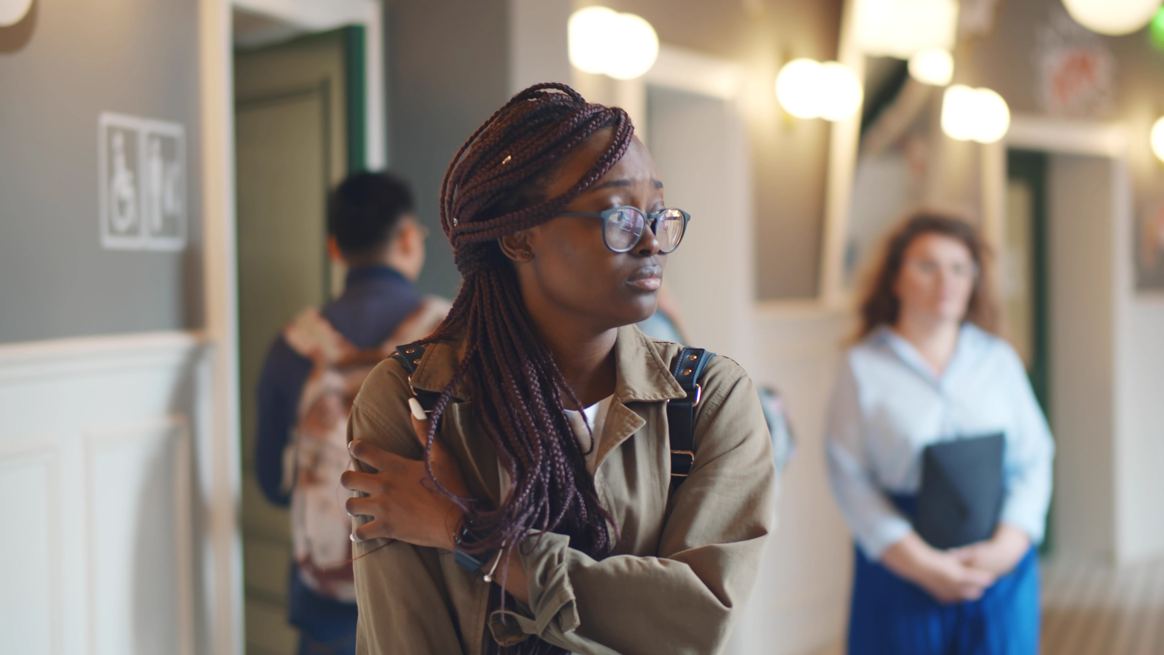 Une adolescente semble mal à l'aise dans le couloir du lycée