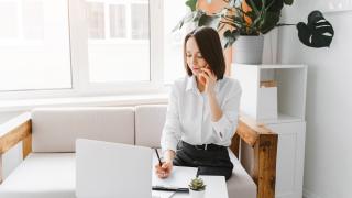 Une personne téléphone devant son ordinateur