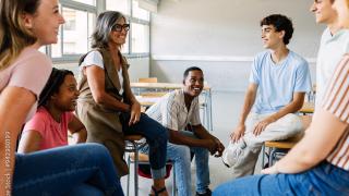 Groupe d'adolescents discutent autour d'un adulte