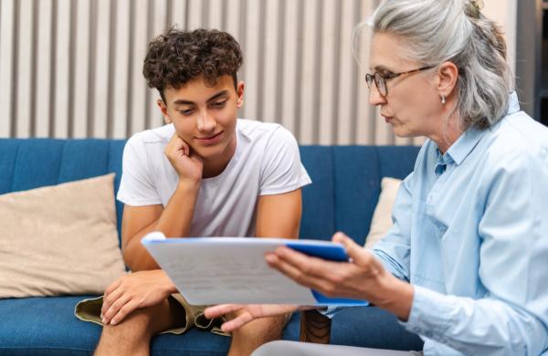 Une adulte et un ado regardent un livre ensemble